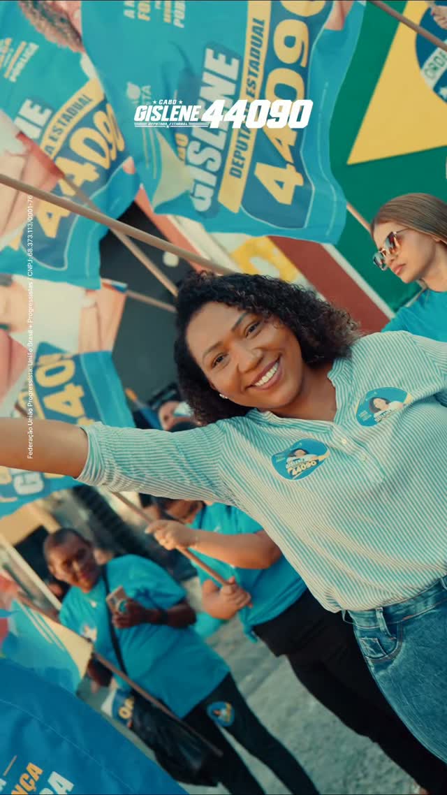 Cabo Gislene sorrindo entre apoiadores e bandeiras da campanha